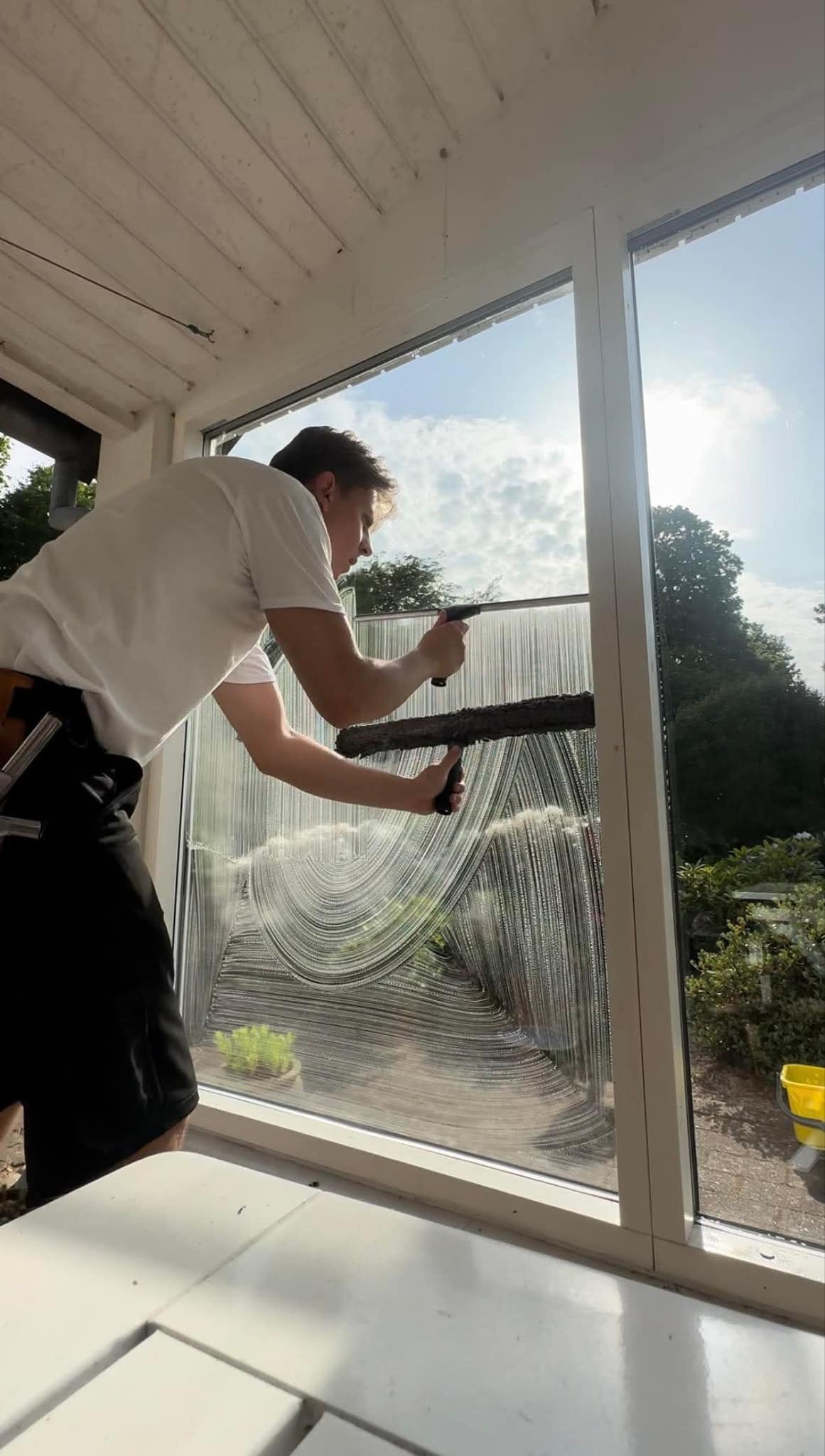 Oscar pudser vinduer indendørs med professionel vinduespudsning i Esbjerg